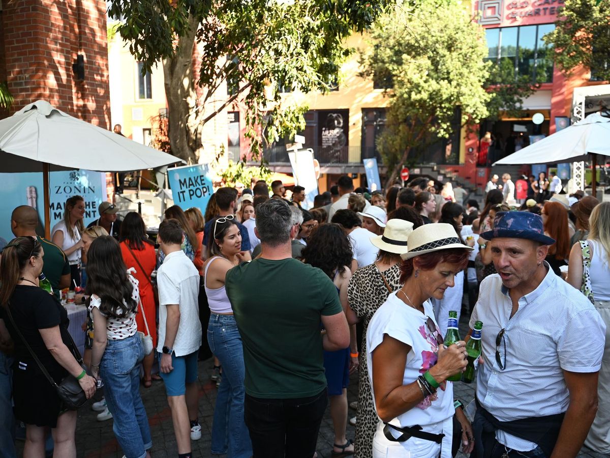 A packed crowd filling the street between the food stalls