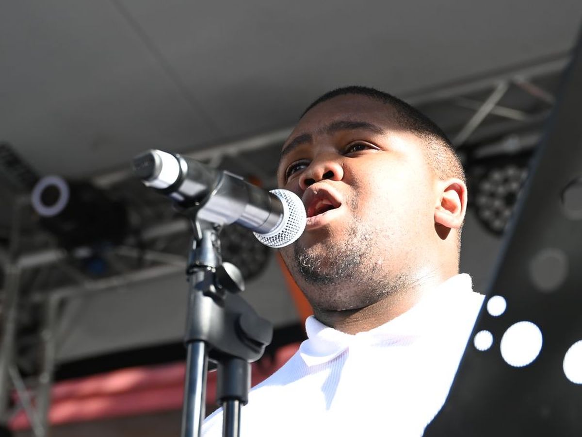 A singer performing live into a microphone on the main stage