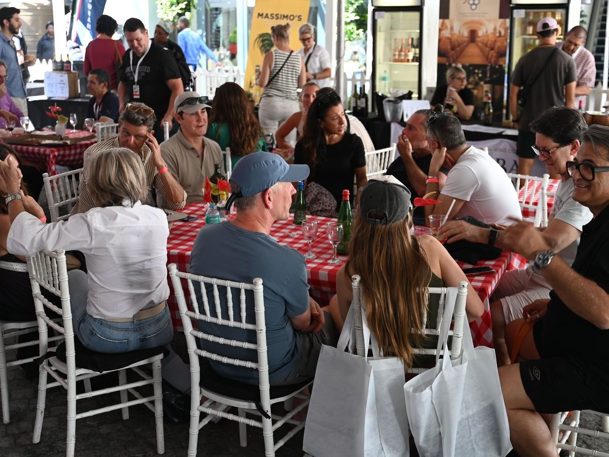Red gingham tables filled with people eating under the marquee