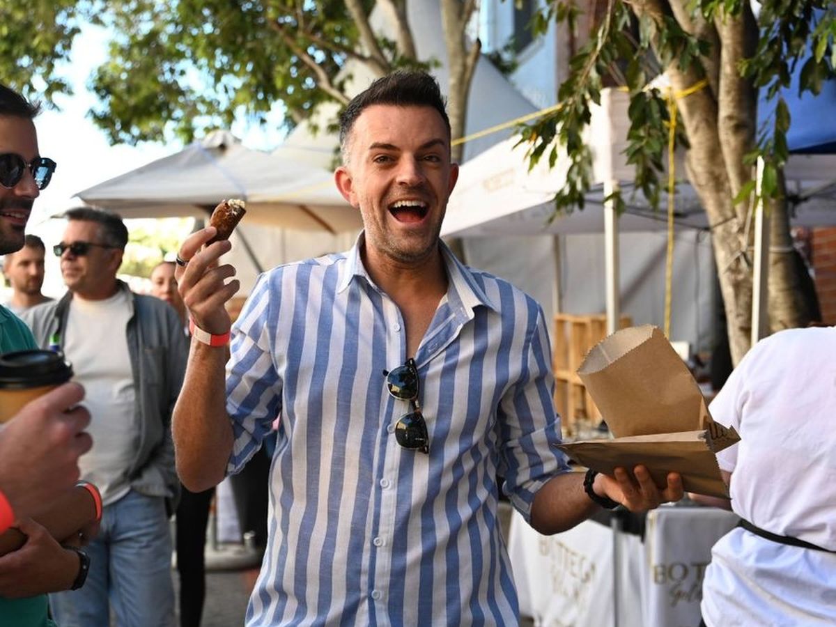 A festival-goer laughing while holding a cannolo