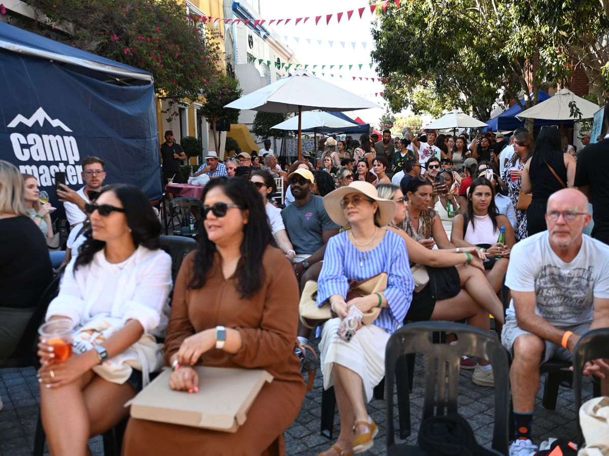 A seated audience watching a performance under the bunting